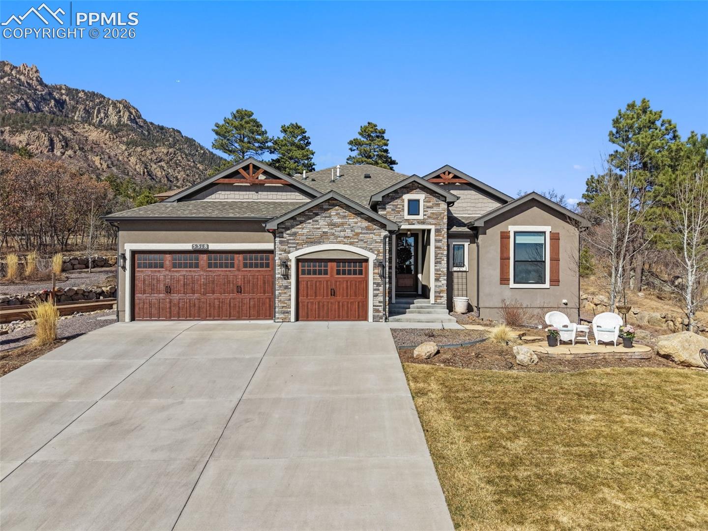 5318 Rocking Tree Grove Colorado Springs, CO 80906 - Photo 1 of 49 Welcome guests with a curated front-facing patio that instantly establishes a connection with the rugged mountain backdrop before even stepping inside