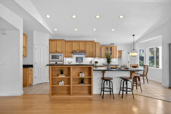 a view of a patio with table and chairs potted plants and large tree