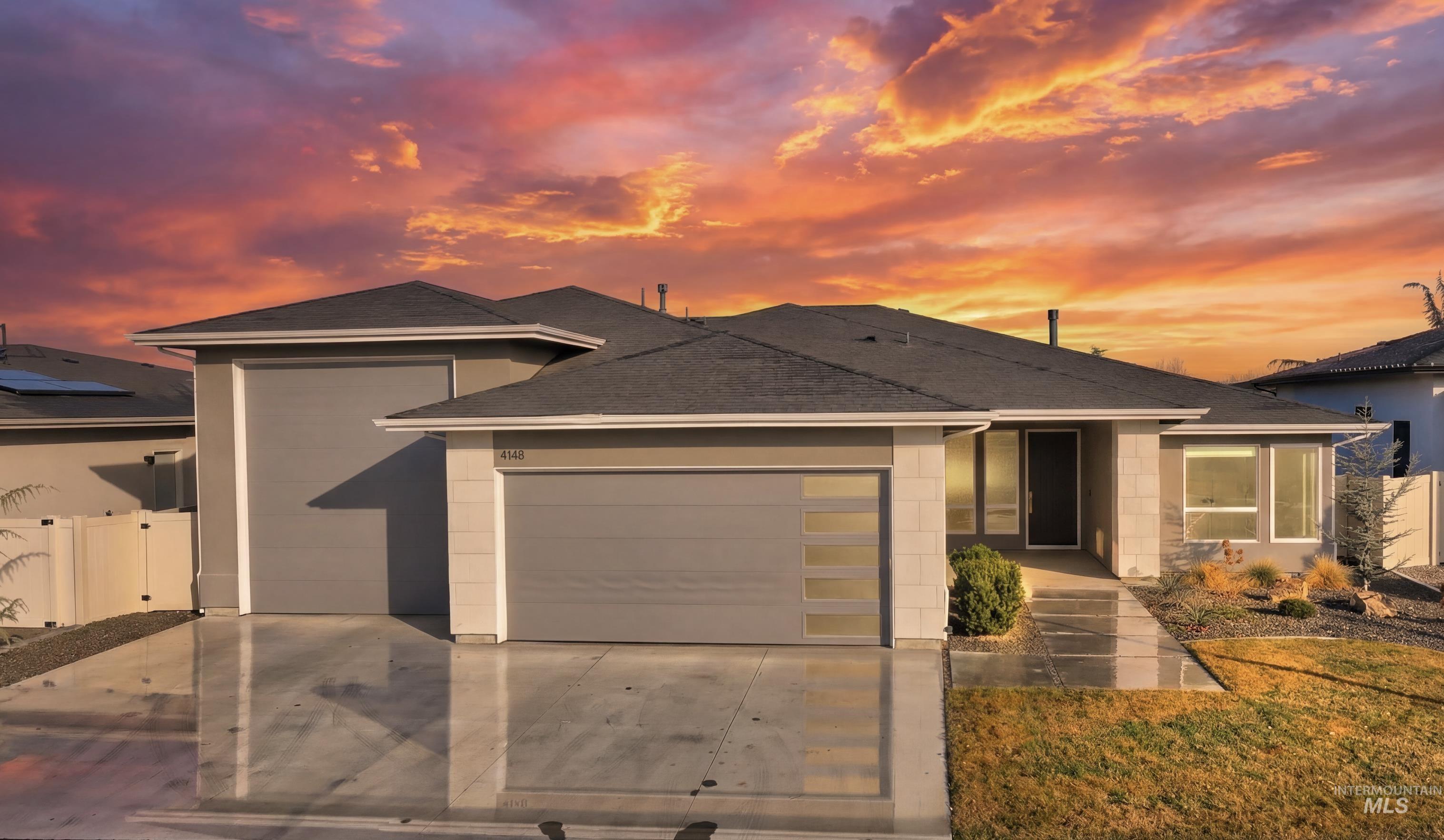 View of front of house featuring a garage, concrete driveway, roof with shingles, and a gate