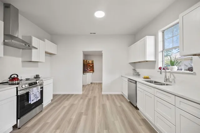 a kitchen with a sink a stove and cabinets