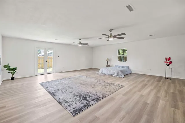 a view of a livingroom with wooden floor and kitchen space