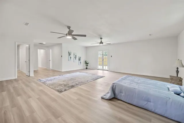 a spacious bedroom with a bed and ceiling fan
