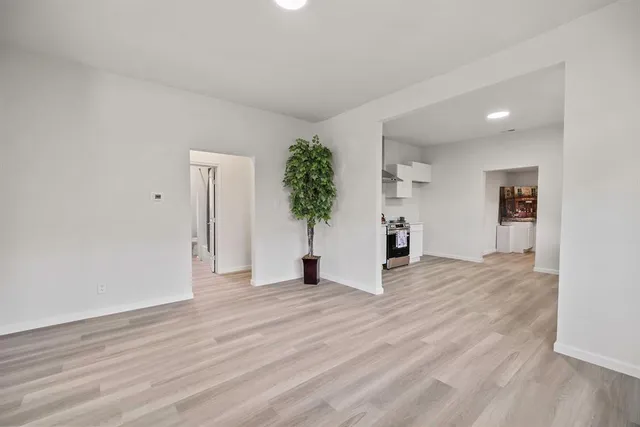 a view of a room with wooden floor and a refrigerator