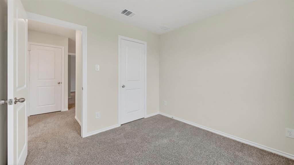 3534 Spring Time Street Forney, TX 75126 - Photo 23 of 24 Neutral-toned room featuring a white interior door, light gray carpeting, and white baseboards