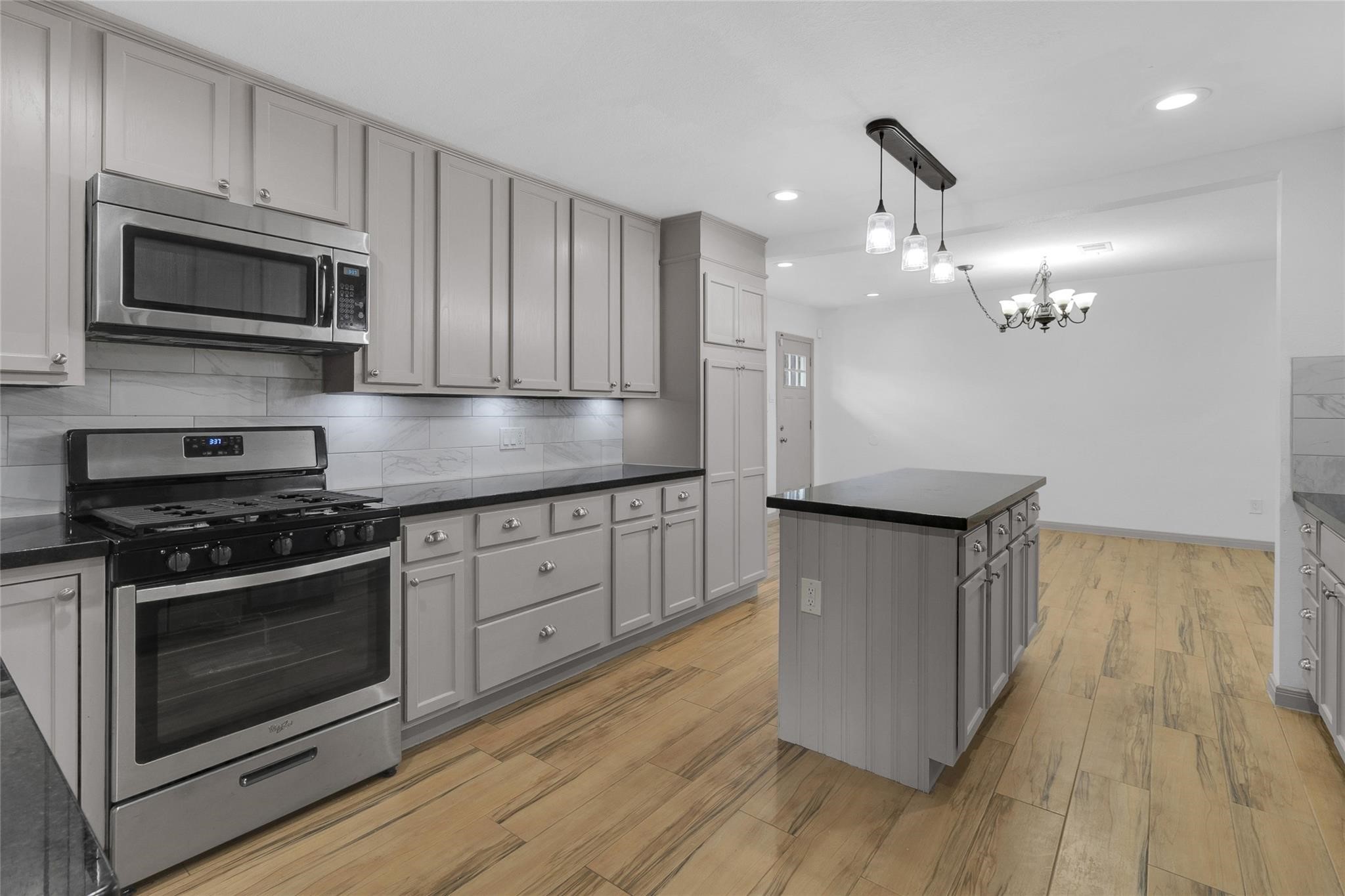 2934 Robertson Street Houston, TX 77009 - Photo 6 of 23 a kitchen with stainless steel appliances granite countertop a stove a microwave and a hard wood floors
