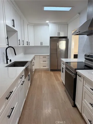 a large kitchen with stainless steel appliances granite countertop a stove and a refrigerator