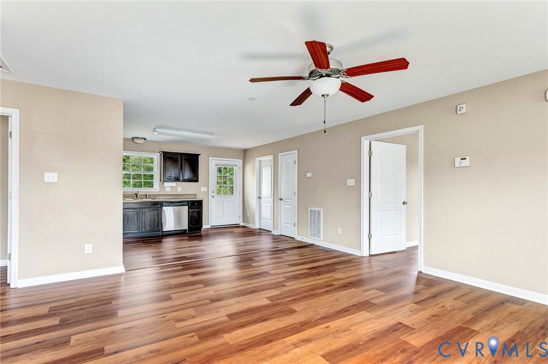 9925 Reymet Court Richmond, VA 23237 - Photo 13 of 30 a view of an empty room and kitchen with a ceiling fan wooden floor and window