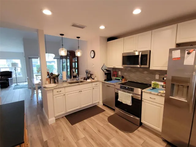 a kitchen with stainless steel appliances granite countertop a stove a sink and a microwave