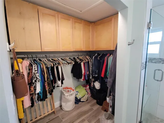 a view of walk in closet with clothes and shoes