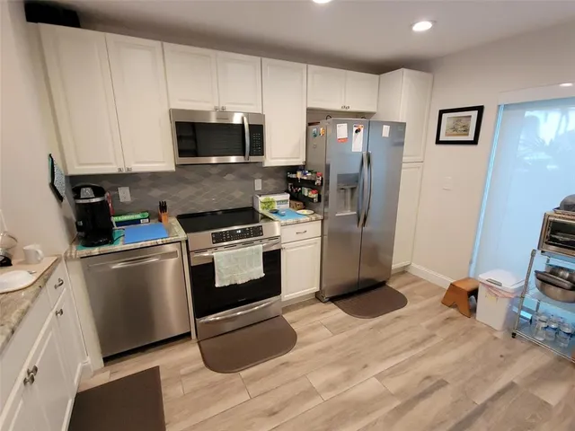 a kitchen with stainless steel appliances a stove a microwave and a refrigerator