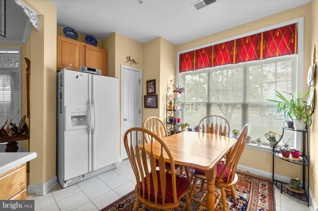 a dining room with furniture a rug a potted plant and a table