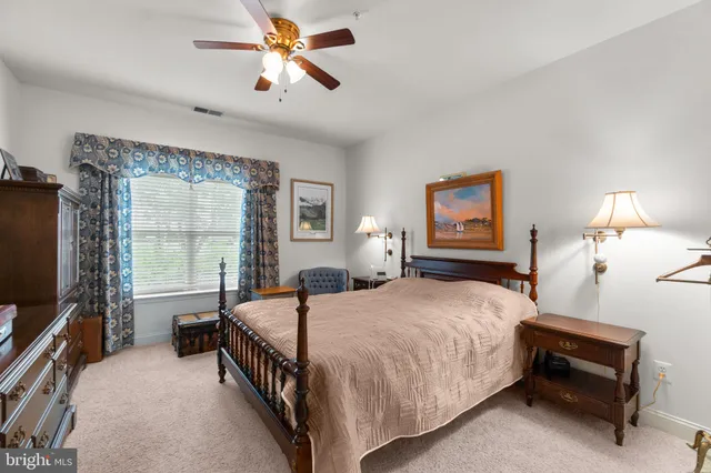 a bedroom with a bed a chandelier and a flat screen television