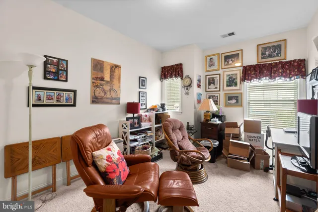 a living room with furniture a couch and paintings on the wall