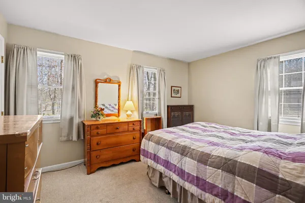 a bedroom with a bed and large windows