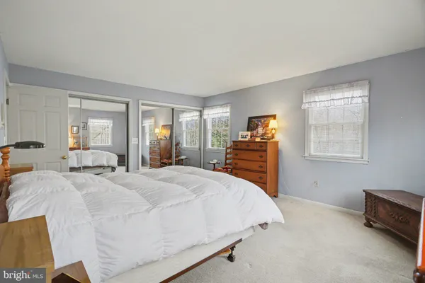 a spacious bedroom with a bed and dresser