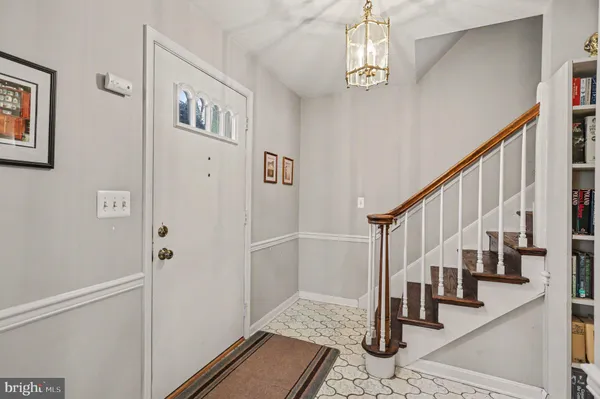 a view of staircase with lots of frames on wall and wooden floor