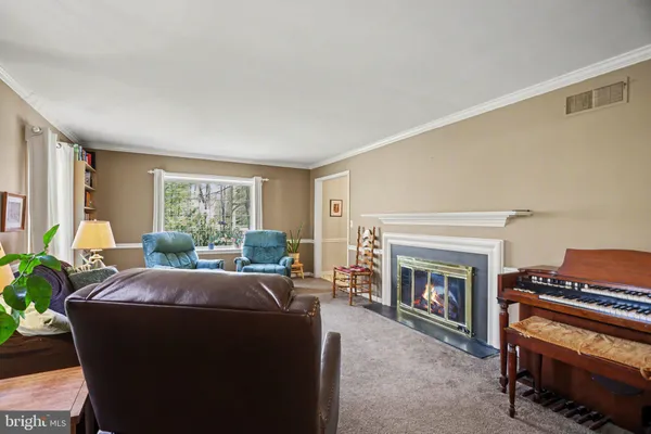 a living room with furniture a fireplace and a window