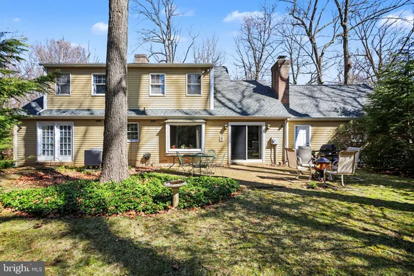 a view of a patio with table and chairs potted plants and large tree