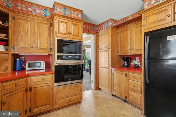 a kitchen with stainless steel appliances granite countertop a refrigerator and a stove top oven