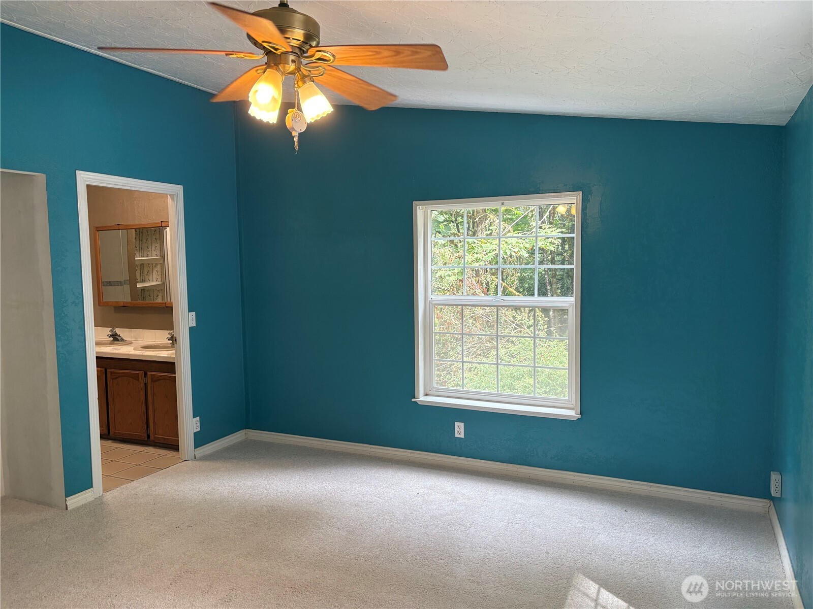 17411 64th St Court Northwest Vaughn, WA 98394 - Photo 18 of 27 a view of an empty room with chandelier fan and a window