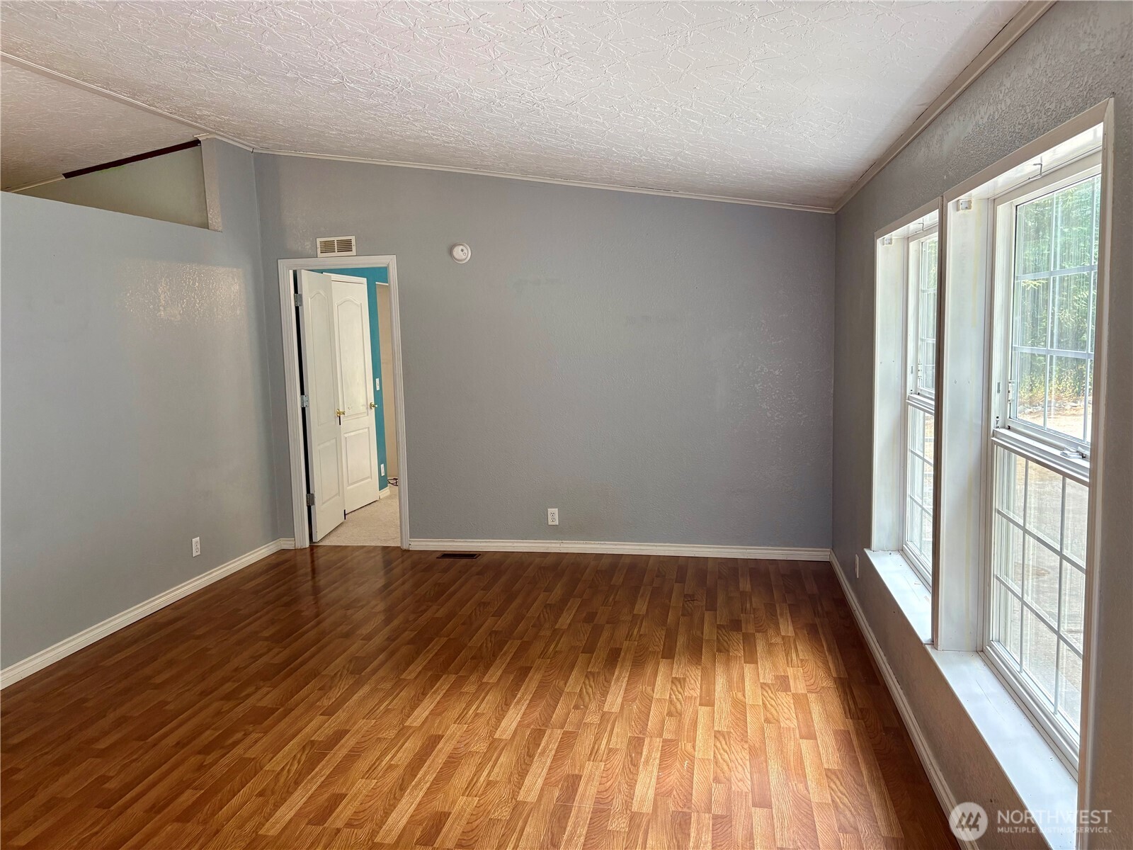 17411 64th St Court Northwest Vaughn, WA 98394 - Photo 7 of 27 an empty room with wooden floor and windows