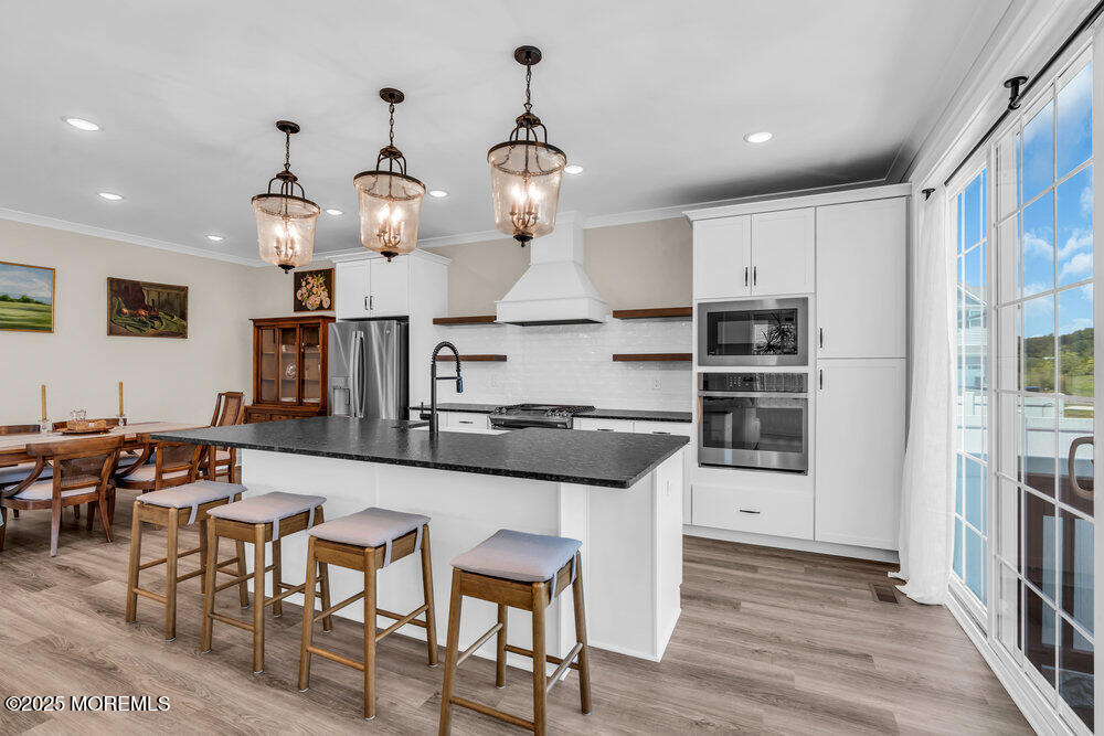 3028 Quail Rdg Boulevard, Unit 606 Farmingdale, NJ 07727 - Photo 15 of 82 a kitchen with stainless steel appliances granite countertop a stove top oven a sink a dining table and chairs with wooden floor