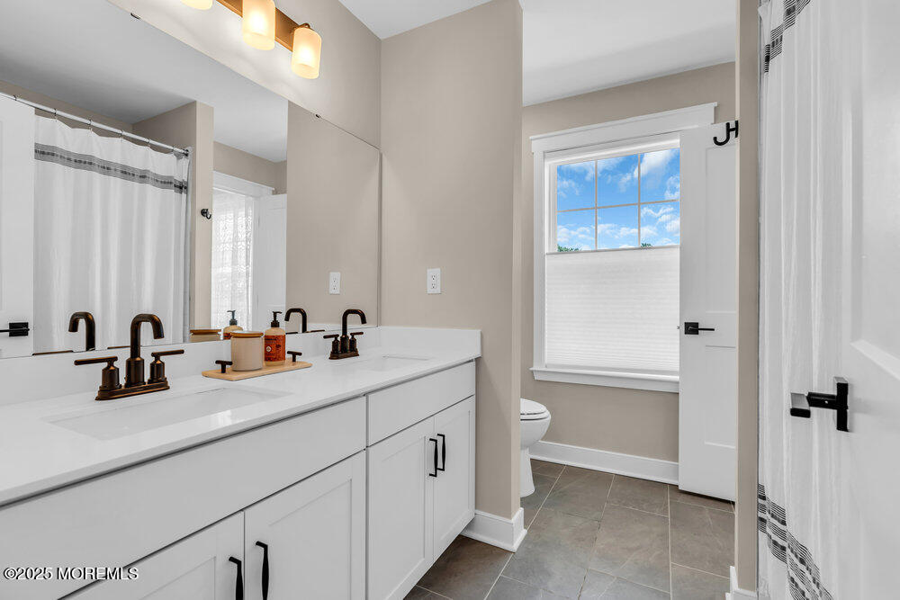 3028 Quail Rdg Boulevard, Unit 606 Farmingdale, NJ 07727 - Photo 43 of 82 a bathroom with a double vanity sink a mirror and a bathtub