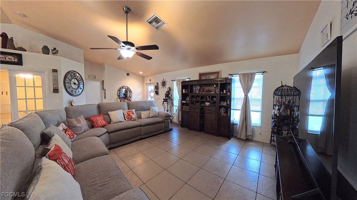 3003 25th Street West Lehigh Acres, FL 33971 - Photo 14 of 25 a living room with furniture a clock and a ceiling fan