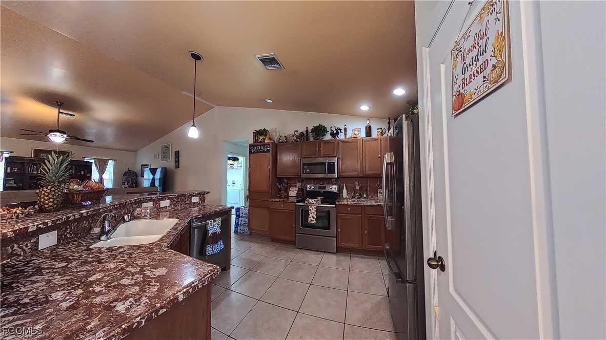 3003 25th Street West Lehigh Acres, FL 33971 - Photo 18 of 25 a view of a kitchen with refrigerator and chairs