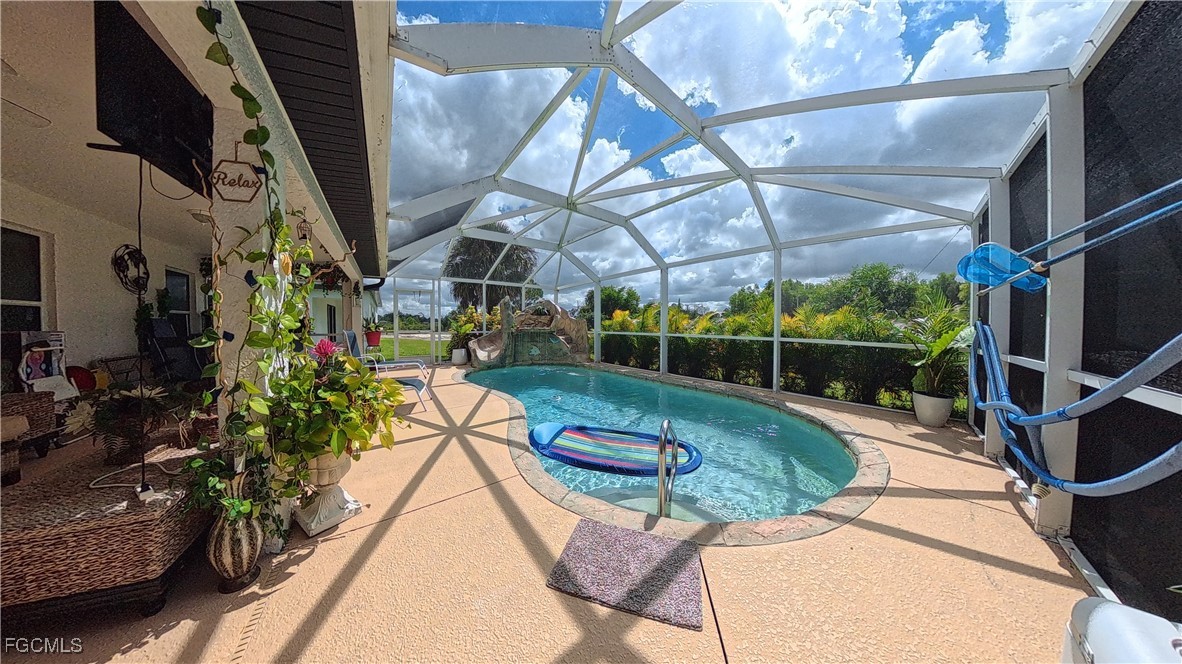 3003 25th Street West Lehigh Acres, FL 33971 - Photo 21 of 25 a view of a swimming pool with a patio and a garden