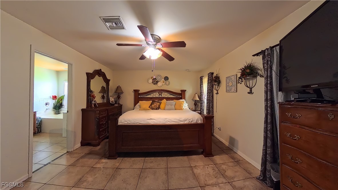 3003 25th Street West Lehigh Acres, FL 33971 - Photo 23 of 25 a bedroom with a bed and a ceiling fan