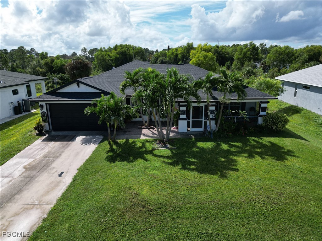 3003 25th Street West Lehigh Acres, FL 33971 - Photo 3 of 25 a view of a garden with a bench in front of the house