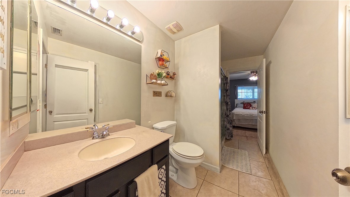 3003 25th Street West Lehigh Acres, FL 33971 - Photo 9 of 25 a en suite bathroom with a sink a toilet and shower