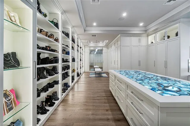 a kitchen with stainless steel appliances granite countertop a lot of cabinets a stove and a wooden floors