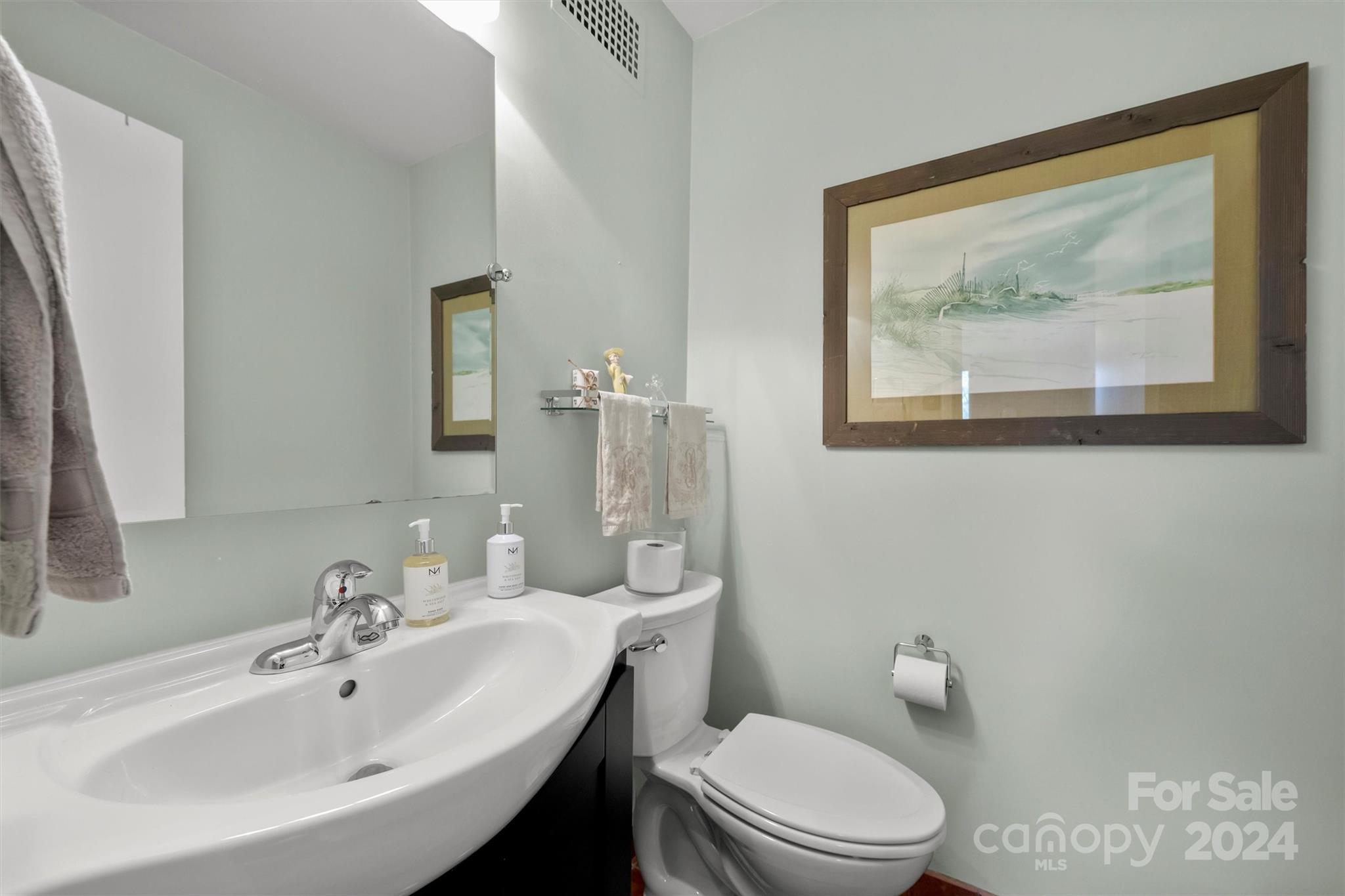 1300 Queens Road, Unit 317 Charlotte, NC 28207 - Photo 16 of 24 a bathroom with a toilet a sink and mirror
