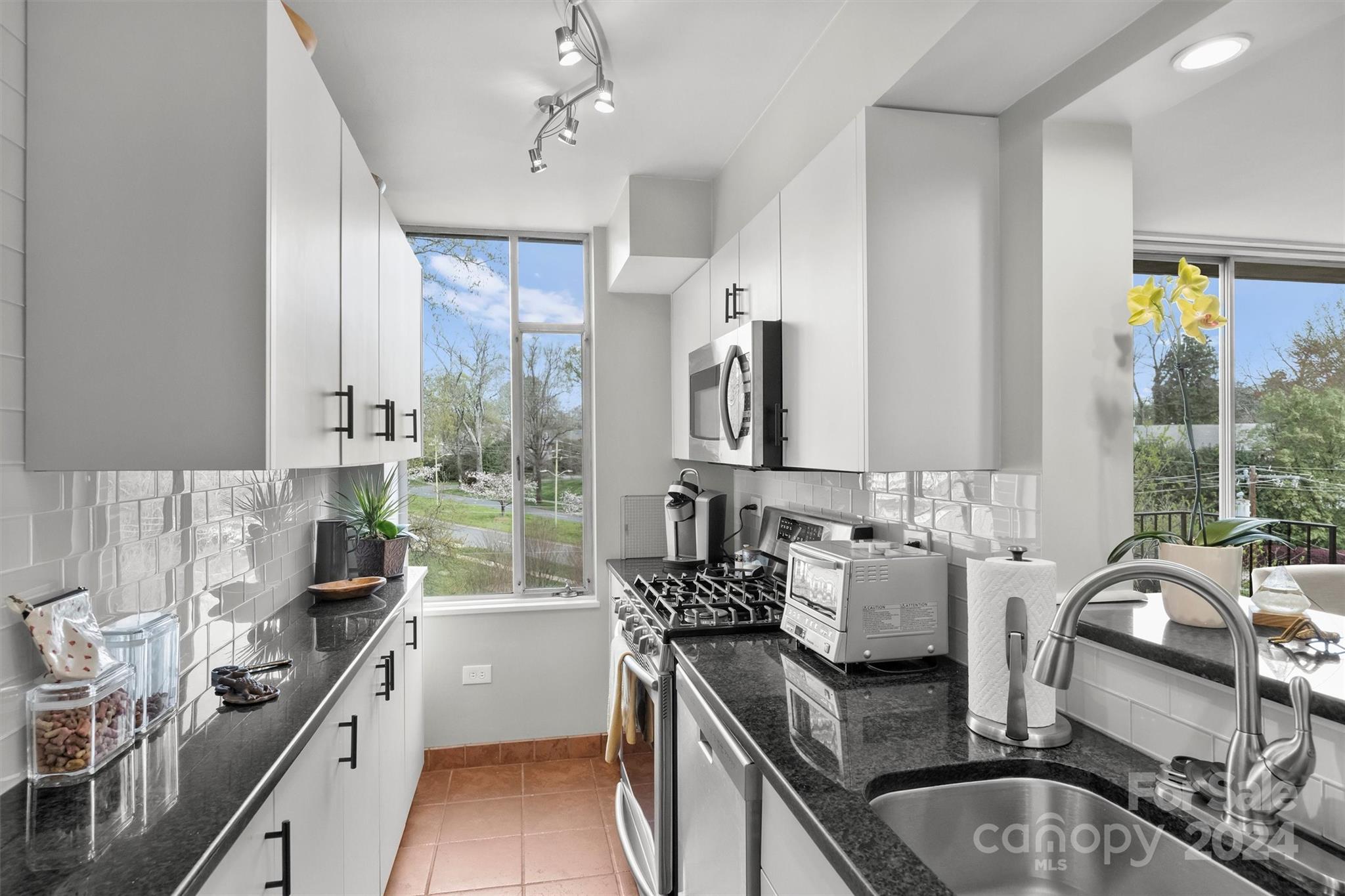 1300 Queens Road, Unit 317 Charlotte, NC 28207 - Photo 8 of 24 a kitchen with stainless steel appliances granite countertop a sink a stove and a refrigerator