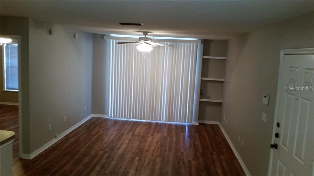 Undisclosed Address Orlando, FL 32819 - Photo 5 of 9 a view of a hallway with wooden floor and chandelier