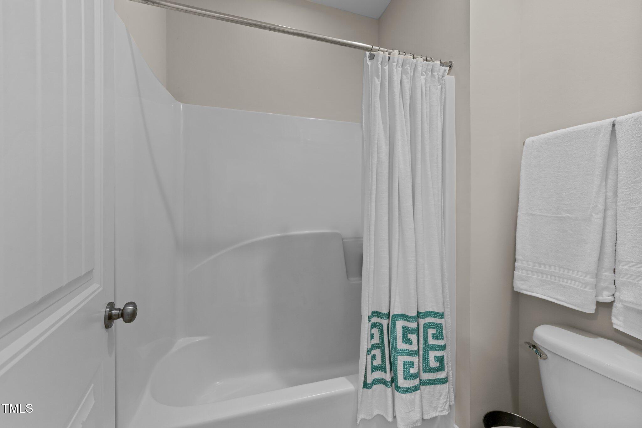 2436 Noble Road Raleigh, NC 27608 - Photo 25 of 40 a bathroom with a shower curtain and a toilet