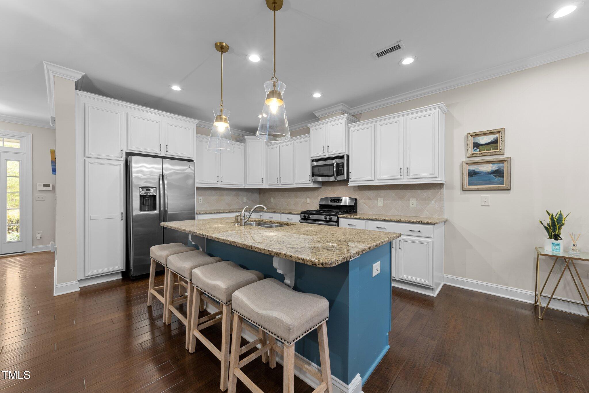 2436 Noble Road Raleigh, NC 27608 - Photo 3 of 40 a kitchen with kitchen island granite countertop a sink a center island and stainless steel appliances