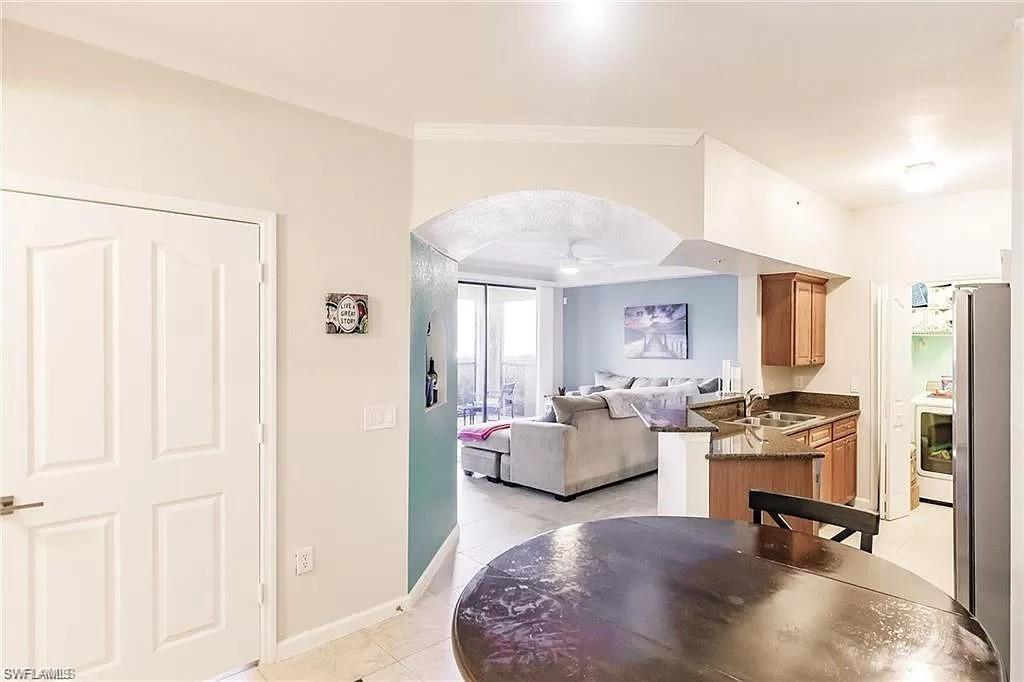 13010 Positano Circle, Unit 101 Naples, FL 34105 - Photo 11 of 29 a living room with furniture and a flat screen tv