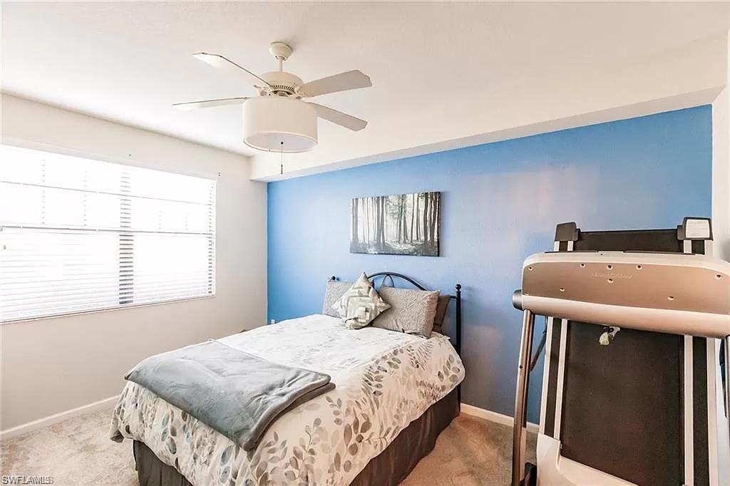 13010 Positano Circle, Unit 101 Naples, FL 34105 - Photo 16 of 29 a bedroom with a bed and a chandelier