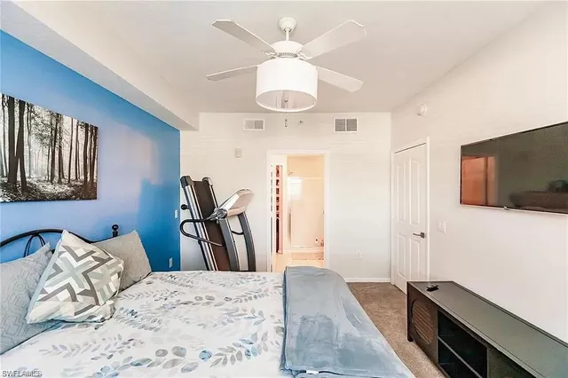 a bedroom with a bed and a flat tv screen on the dresser