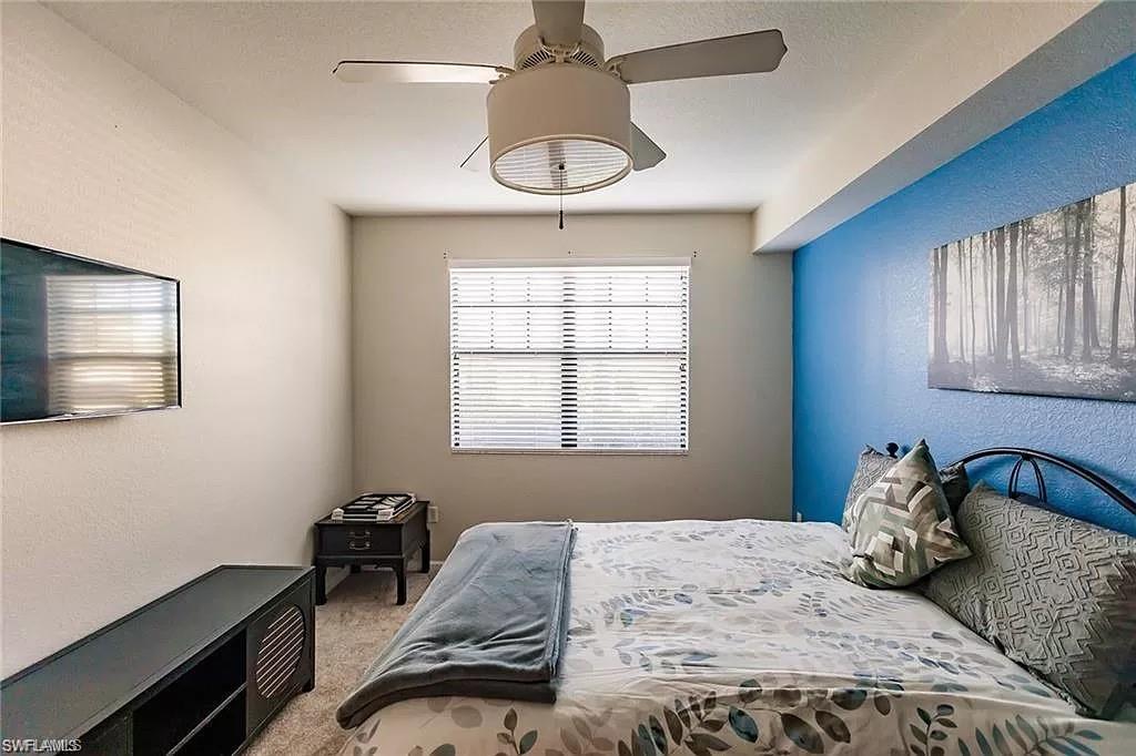 13010 Positano Circle, Unit 101 Naples, FL 34105 - Photo 19 of 29 a bedroom with a bed and a window
