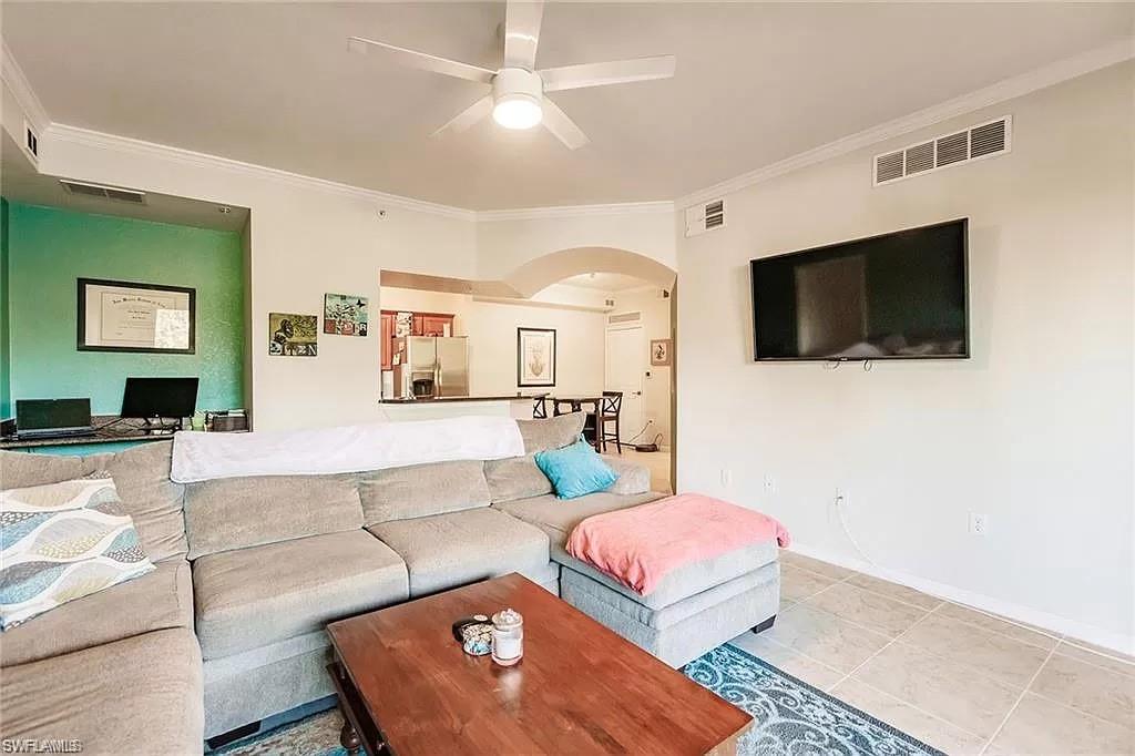 13010 Positano Circle, Unit 101 Naples, FL 34105 - Photo 5 of 29 a living room with furniture and a flat screen tv
