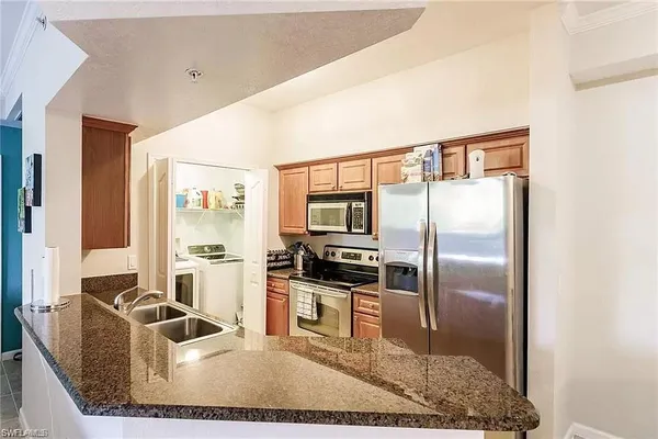 a kitchen with kitchen island a counter top stainless steel appliances and a counter top space