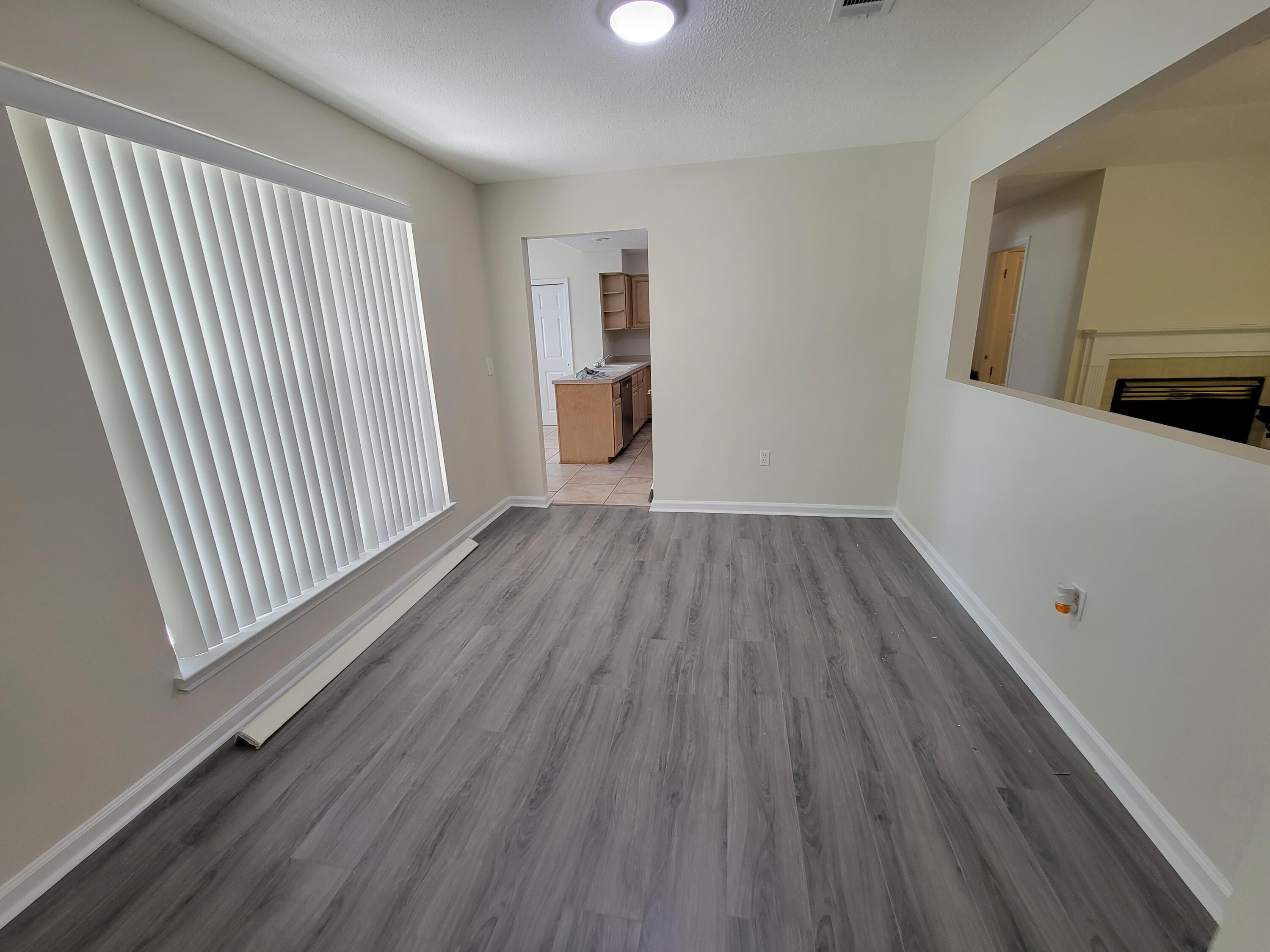 45 Hidden Lakes Trail DeFuniak Springs, FL 32433 - Photo 14 of 39 an empty room with wooden floor and windows