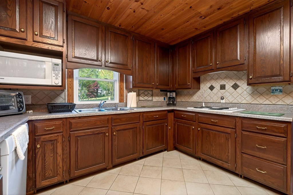 1932 Holly Creek Road Celina, TN 38551 - Photo 4 of 31 a kitchen with stainless steel appliances granite countertop wooden cabinets a stove top oven a sink and dishwasher with wooden floor