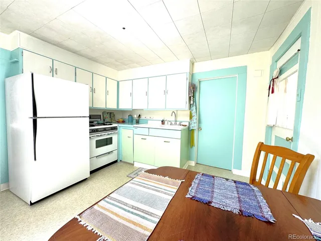 a kitchen with a refrigerator and a more cabinets