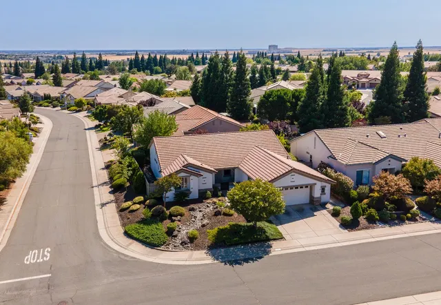 an aerial view of a house with a yard and lake view