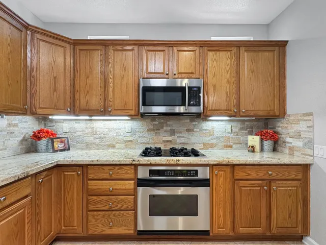 a kitchen with granite countertop cabinets stainless steel appliances and a sink